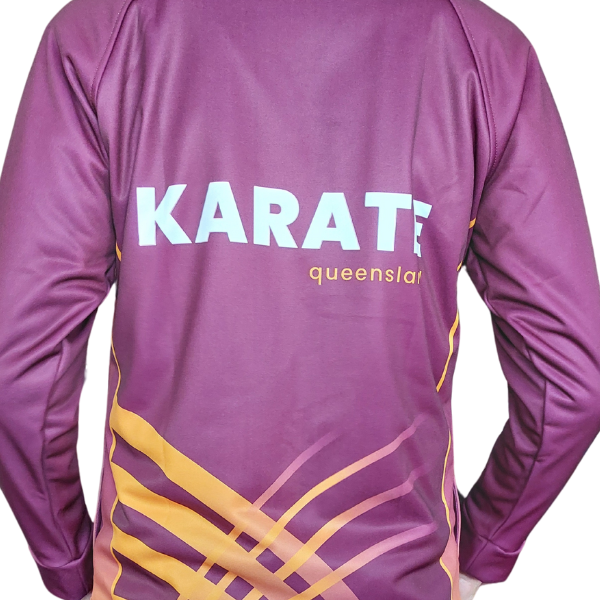 A maroon Karate Queensland tracksuit top featuring the word "KARATE" in bold white lettering and "queensland" in smaller gold text across the upper back. The lower back displays a dynamic gold and maroon graphic design