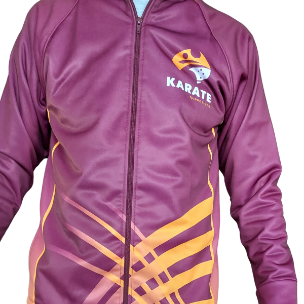 A front view of the official Karate Queensland tracksuit top, zipped up and worn by a model. The maroon jacket features the Karate Queensland logo on the left chest and a sweeping gold and maroon graphic across the lower front.